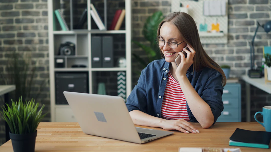 A salesperson on a phone call at a laptop