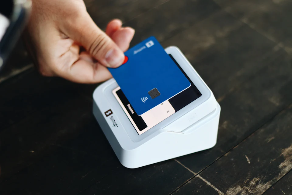 A customer tapping a card on a payment terminal